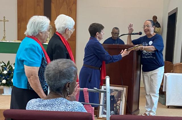 Lynne Lieux, RSCJ, accepts a plaque of gratitude on behalf of the RSCJ from Pauline Edmond, alumna of St. Peter Claver High School and member of the reunion committee.